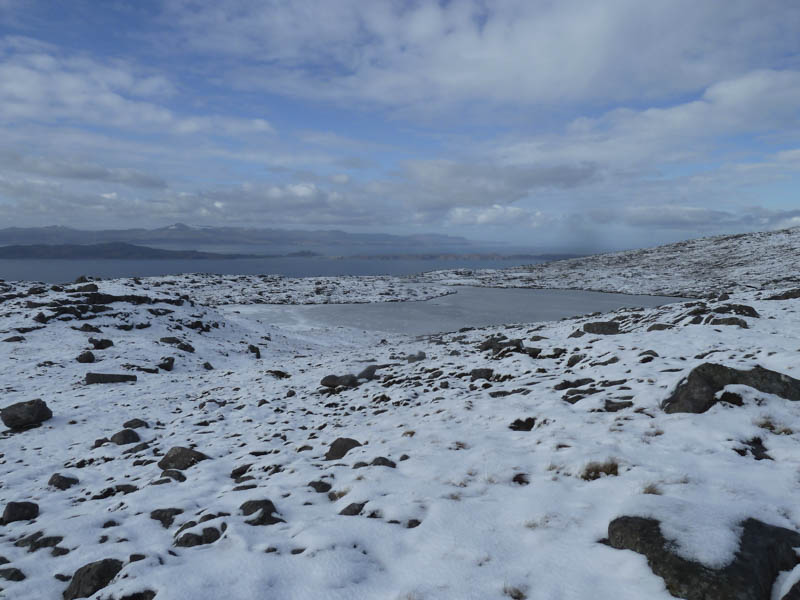 Frozen lochan. Isles of Raasay and Rona beyond